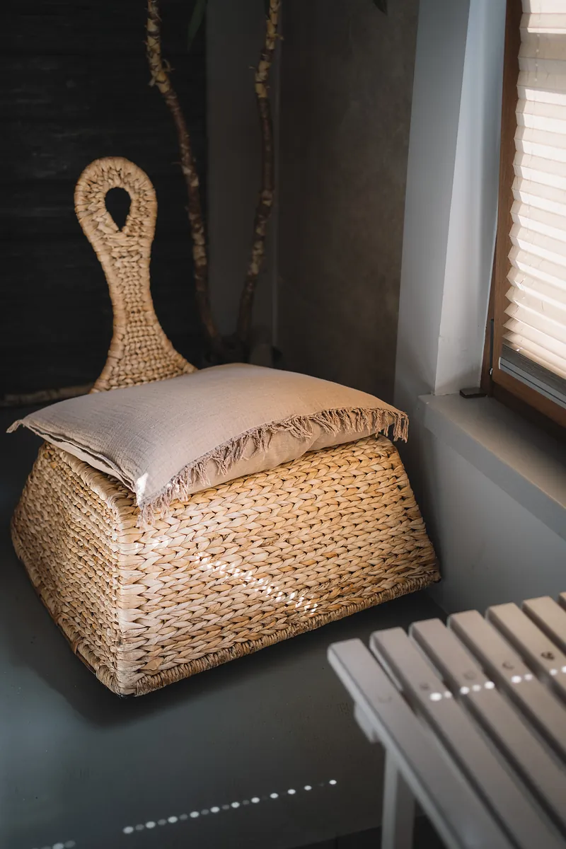 Woven basket with folded towels by the window